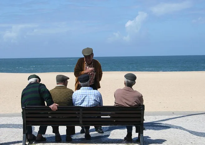 5 old men sitting on bench by beach 5 old men sitting on bench by beach